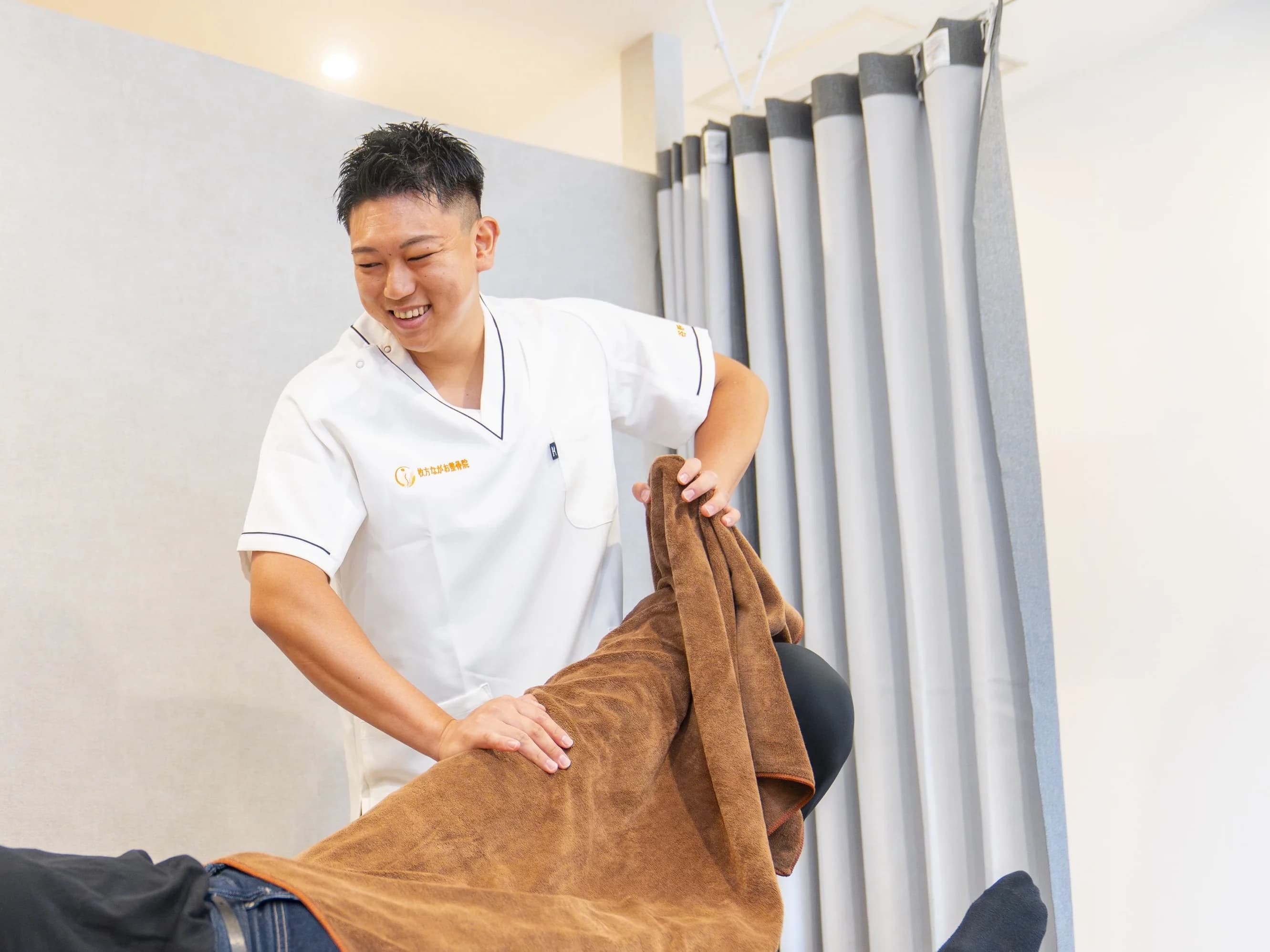 院長が笑顔でストレッチ施術を行う様子